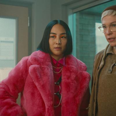 Two women looking skeptical, one in a pink fur coat.