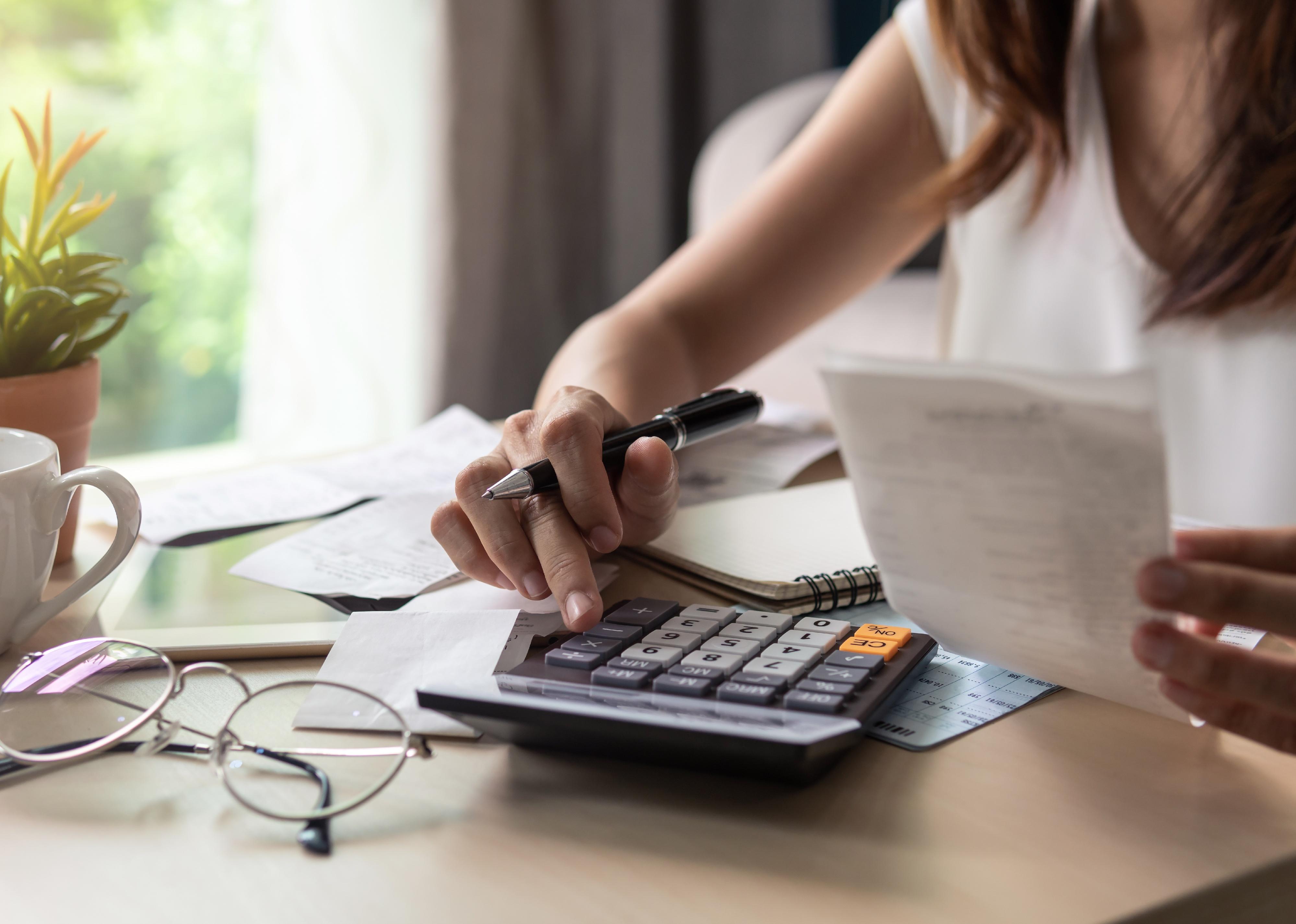 Stressed young woman calculating expenses