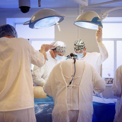 Masked surgeons perform surgery.