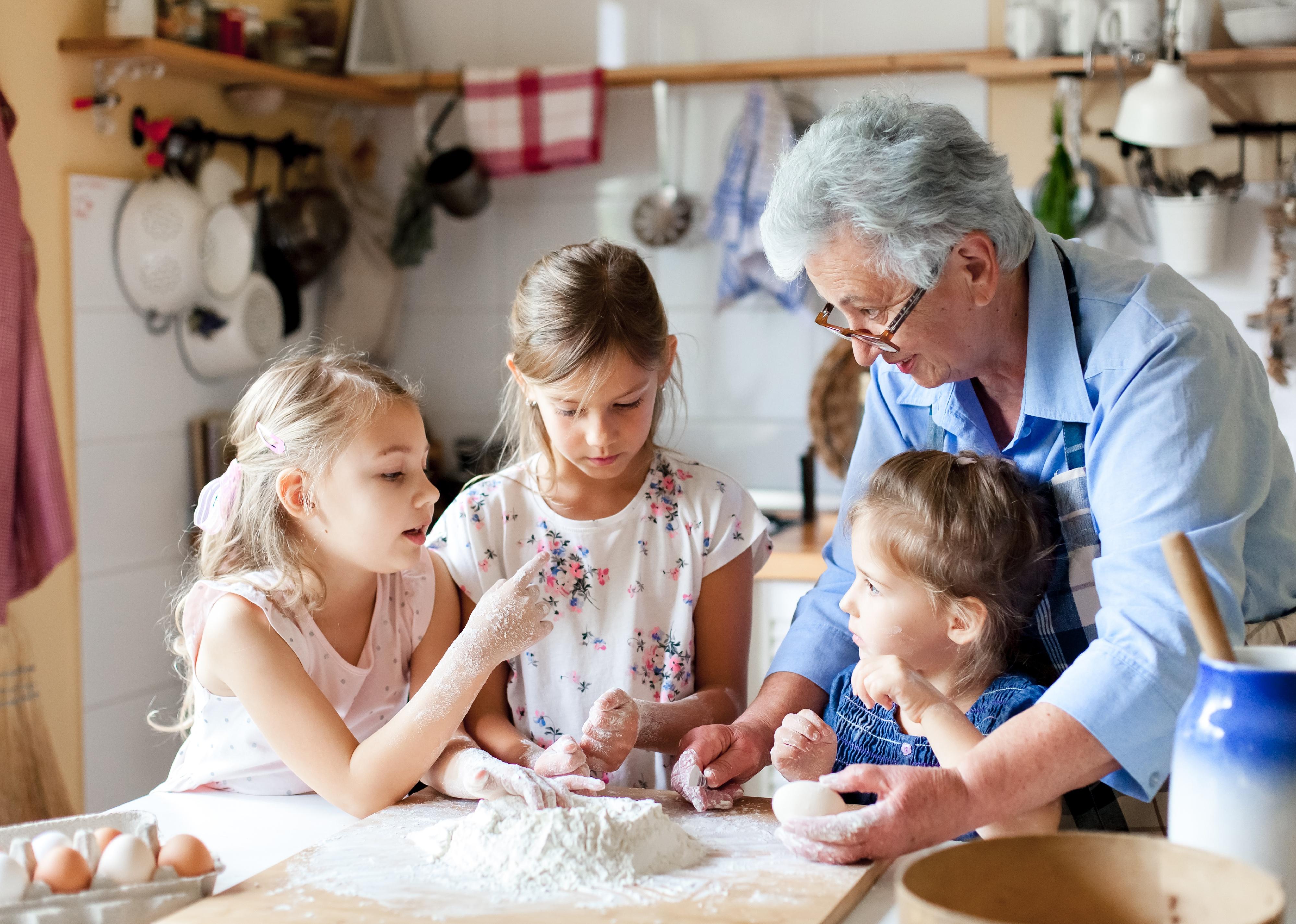 Grandmother and kids baking bread.