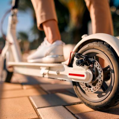 Close-up image of a person's feet on an electric scooter.