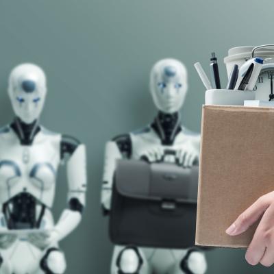 Office worker holding a box with belongings and leaving office, with AI robots waiting for job interview in the background.