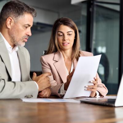 Two business executives discussing financial papers.