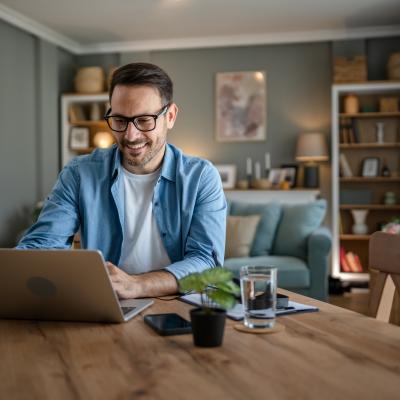 Man working on his laptop at his kitchen table. 