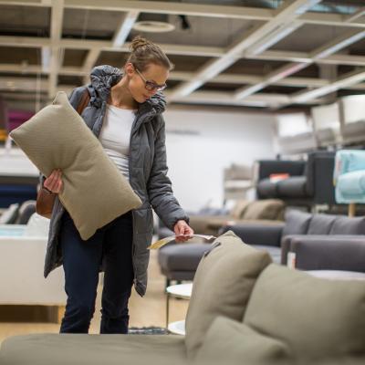 Young woman shopping for a couch in a home furnishings store.