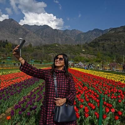 A woman taking a selfie in a field of flowers.