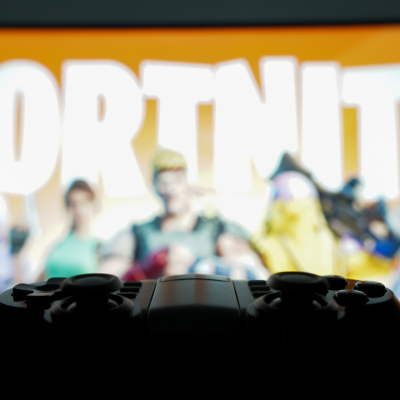 A game controller and Fortnite in the background.