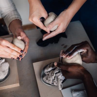 Hands working on pottery.