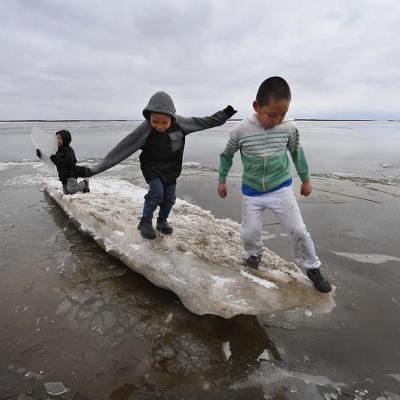  Schoolchildren play on melting ice at the climate change affected Yupik village of Napakiak on the Yukon Delta in Alaska on April 18, 2019.