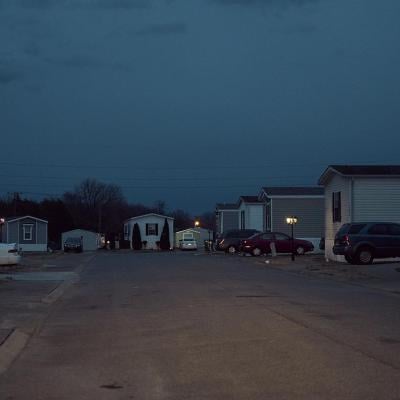Dusk falls on cars parked next to mobile homes in a mobile park owned by a private equity firm in Smyrna, Tennessee. 