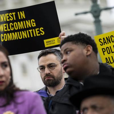 People hold signs in support of sanctuary city mayors outside the U.S. capitol, on Wednesday, March 5, 2025 in Washington, D.C.