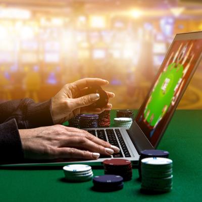 Person using laptop playing online casino.