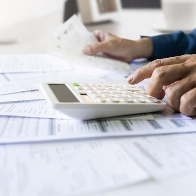 Man calculating figures from paper bills of expenses and other finance documents.