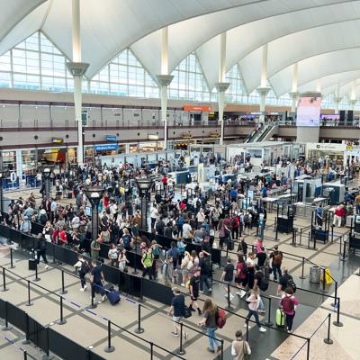 A high-angle view of a crowded TSA security checkpoint at Denver International Airport (DIA).