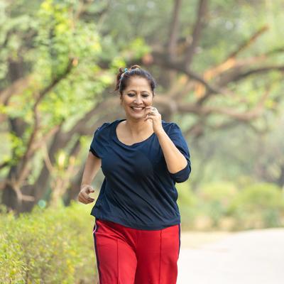 A middle-aged woman jogging at the park.