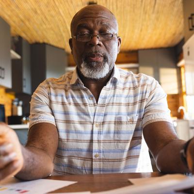Senior man staring and signing finance documents.