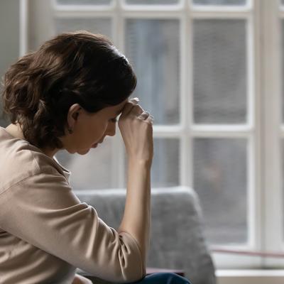 A middle aged woman sits in a worried state.