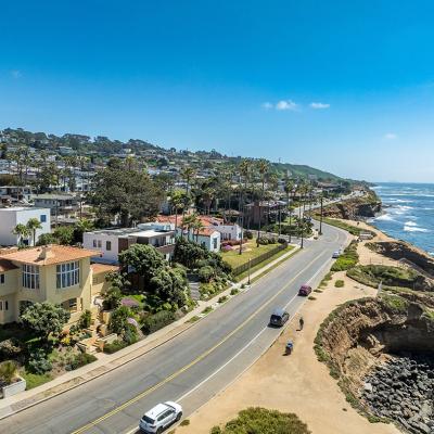 Aerial view of hillside luxury single family homes above Sunset Beach, San Diego with palm trees and terraces.