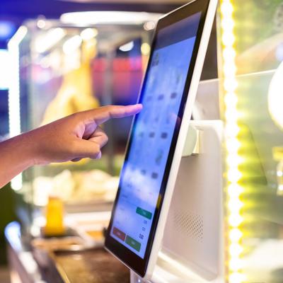 Customer using a digital menu to choose their food and pay electronically.
