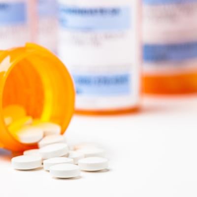 Prescription tablets spilling from bottle.