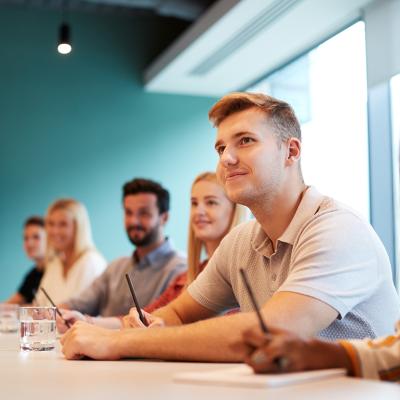 A group of post-graduate candidates in a boardroom.