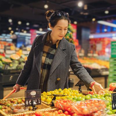 Young woman selecting fresh produce at the grocery store.
