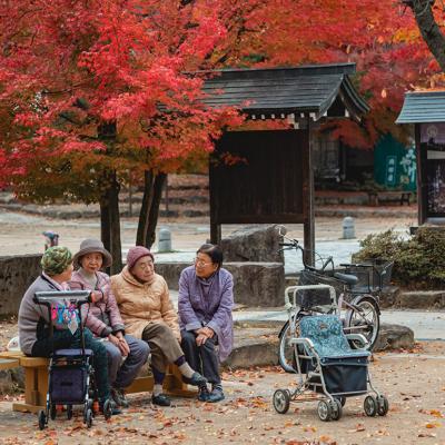 Four elderly women chatting in a garden in Takayama, Japan.
