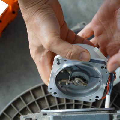 A mechanic repairing an AC servo motor.