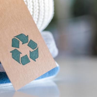 Knitted clothes with a craft tag showing the recycling symbol.