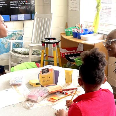 Volunteer Gae Bryant, right, works on a drawing exercise with two students in the K-2 class at The Ferguson School, a microschool that meets in an Atlanta-area church.