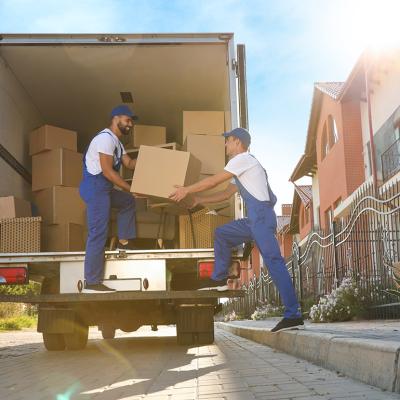 Two workers unloading boxes from a truck servicing a relocation.