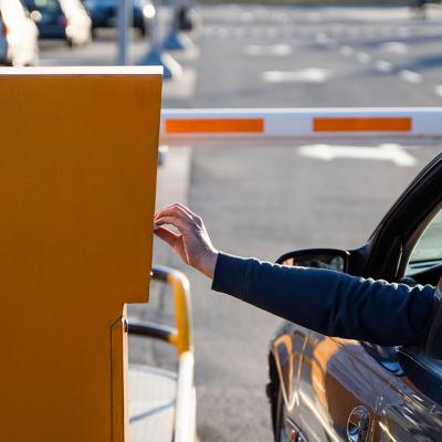Person in the car paying for a parking ticket.