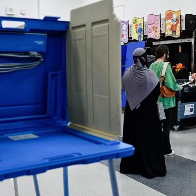 An election official assists voters ready to turn in their ballots for the US presidential and congressional elections at Dearborn High School in Dearborn, MI, United States on November 05, 2024.