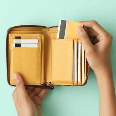 Person taking out a credit card from a wallet.