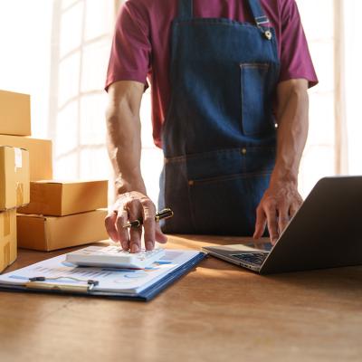 Small business owner calculating orders.