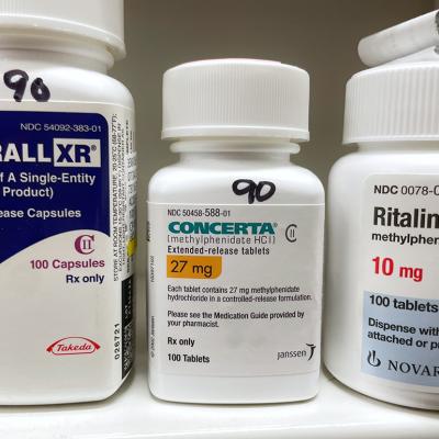 Bottles of ADHD medications such as Adderall, Concerta, and Ritalin.