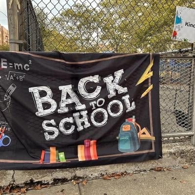 A black "Back to School" banner hangs outside a New York pre-school enrolling a pre-kindergarten class.