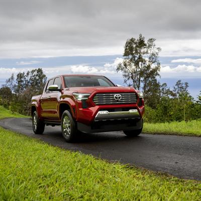 A red 2025 Toyota Tacoma on the road.