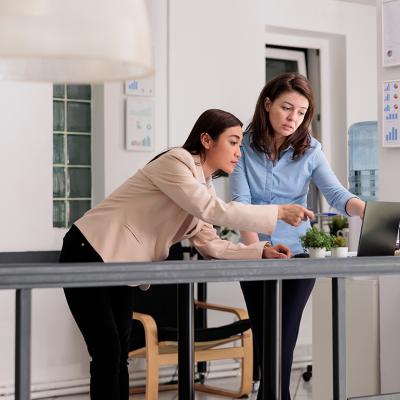 Two female coworkers discussing a company report.