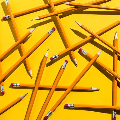 Scattered pencils on a yellow background.