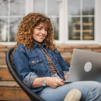 Woman sitting at home while browsing information using a laptop.