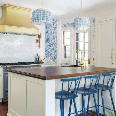 French style country kitchen with white tile, dark countertops and blue and white wallpaper accents.