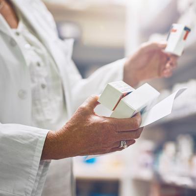 Pharmacist looking at multiple boxes of drugs.