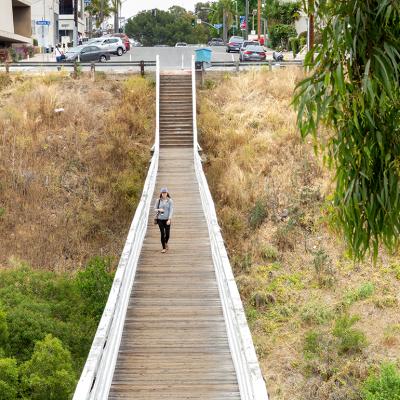 A woman walking across the Quince Street Bridge in Banker's Hills in San Diego, California.