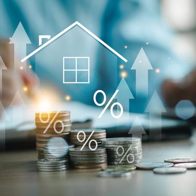 Home insurance and real estate protection concept graphics over stacks of coins.