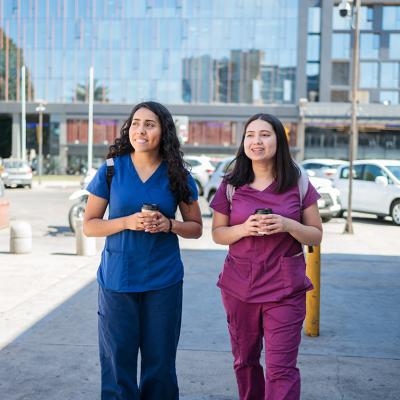 Two young female nurses having coffee after work.