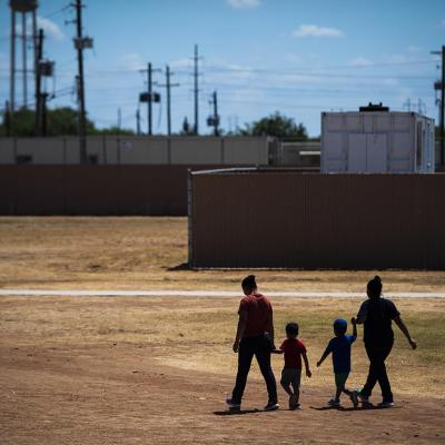 Immigrant woman and children walk across a field as U.S. Immigration and Customs Enforcement (ICE) and Enforcement and Removal Operations (ERO) hosts a media tour at the South Texas Family Residential Center, August 2019.