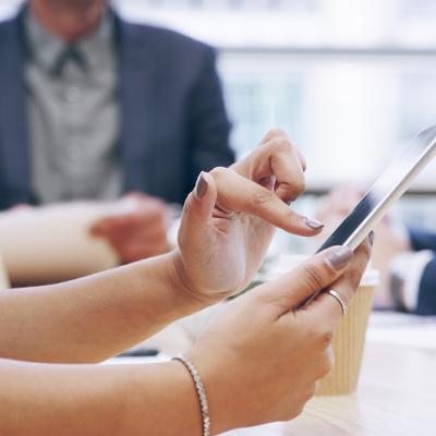 Businesswoman using a tablet during a team meeting.