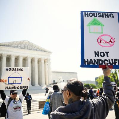 Homeless rights activists hold up signs saying "Housing, Not Handcuffs" outside of the U.S. Supreme Court on April 22, 2024 in Washington, DC.