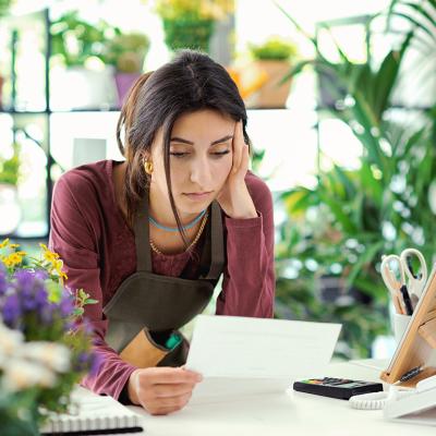 A small plants business owner worried looking at a bill.